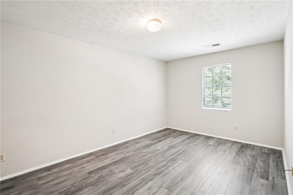 1608 Pine Tree Trail Atlanta, GA 30349 - Photo 9 of 17 an empty room with wooden floor and windows