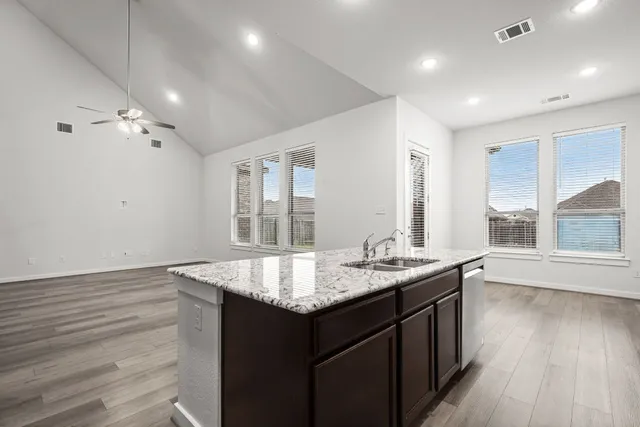 a kitchen with stainless steel appliances granite countertop a refrigerator stove microwave and sink