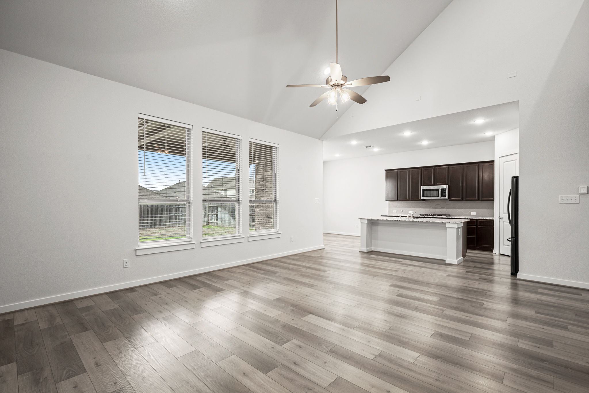 841 Spinnaker Loop Kyle, TX 78640 - Photo 15 of 40 Unfurnished living room with a ceiling fan, light wood-style flooring, and high vaulted ceiling