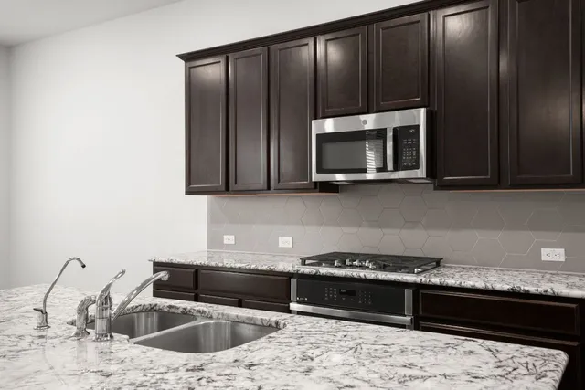 a kitchen with stainless steel appliances granite countertop a sink and a refrigerator