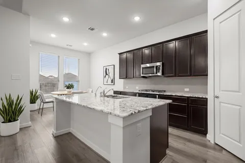 a kitchen with stainless steel appliances granite countertop a refrigerator stove microwave and sink