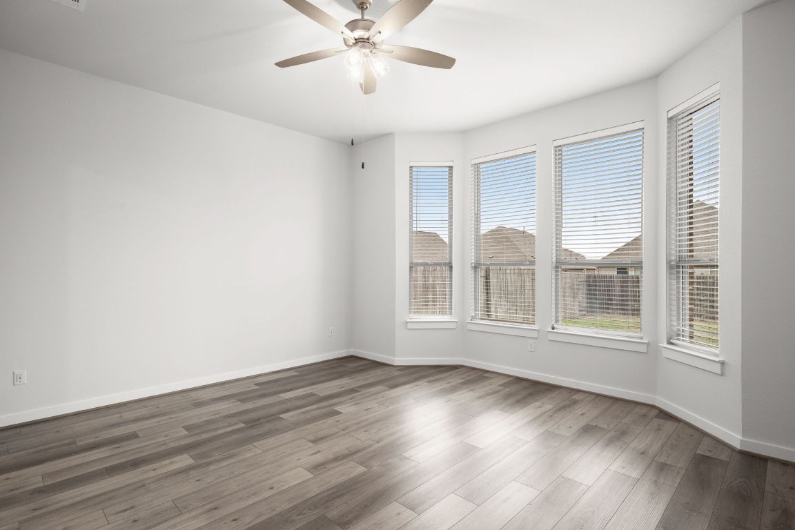 841 Spinnaker Loop Kyle, TX 78640 - Photo 22 of 40 a view of an empty room with a window and wooden floor