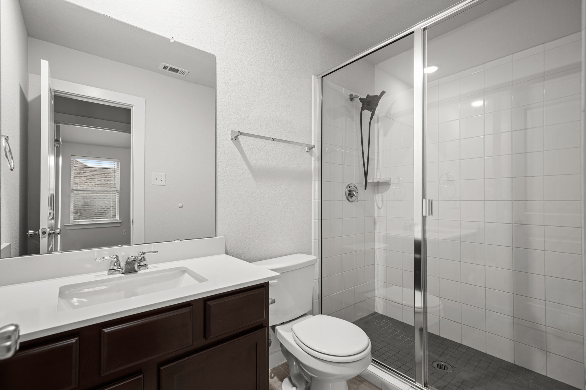 841 Spinnaker Loop Kyle, TX 78640 - Photo 32 of 40 Bathroom with vanity, a shower stall, and a textured wall