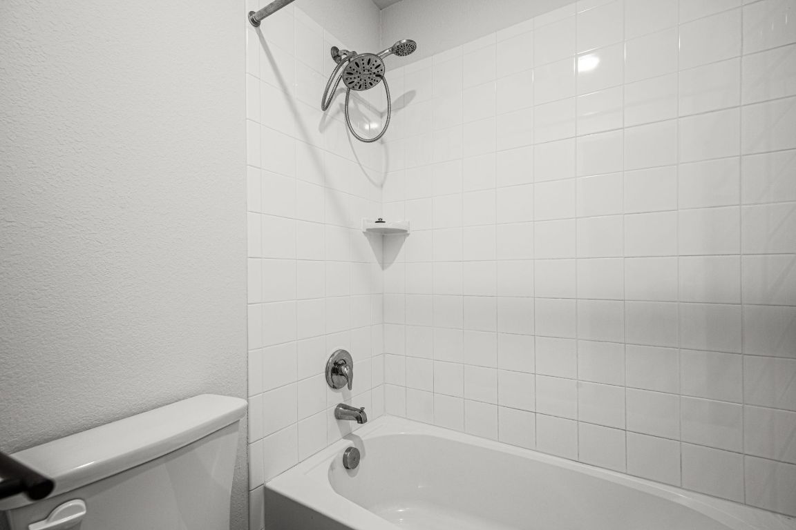 841 Spinnaker Loop Kyle, TX 78640 - Photo 34 of 40 a bathroom with a granite countertop bathtub a toilet and a shower