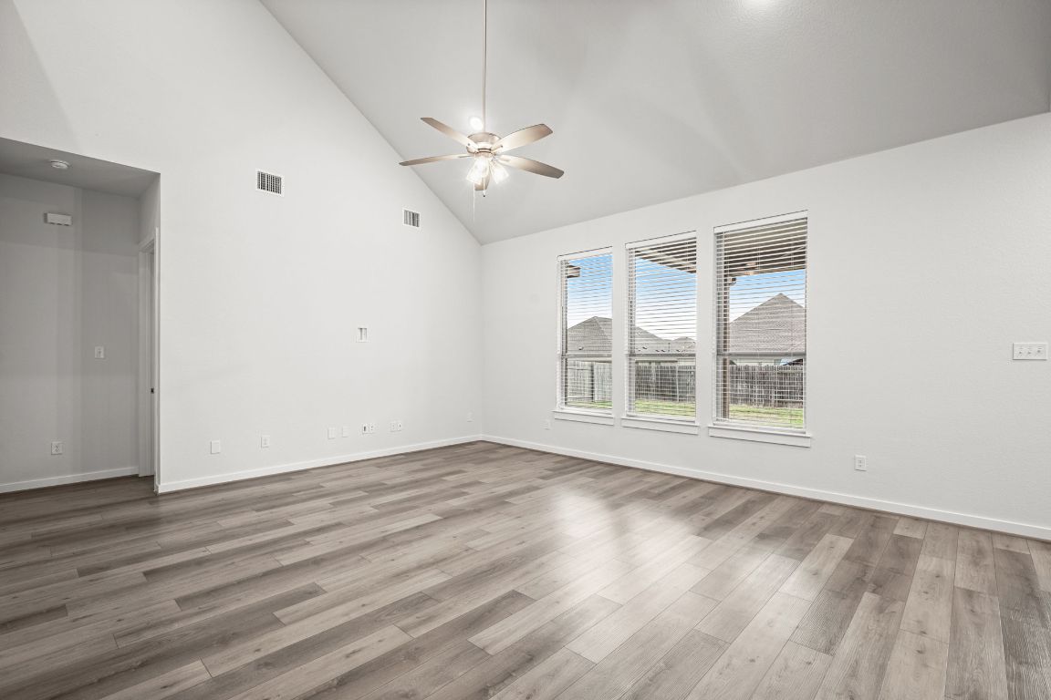 841 Spinnaker Loop Kyle, TX 78640 - Photo 10 of 40 a view of an empty room with wooden floor and a window