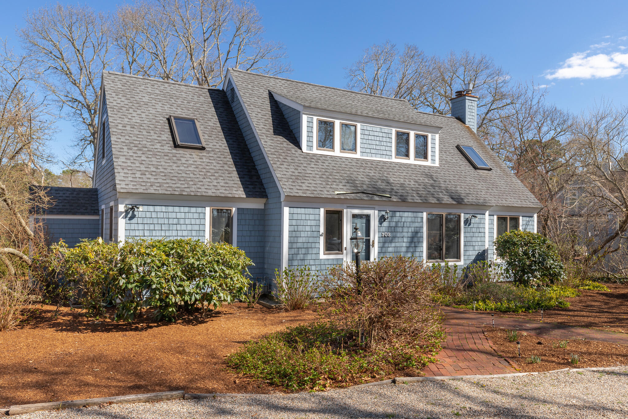 a front view of a house with a yard and trees