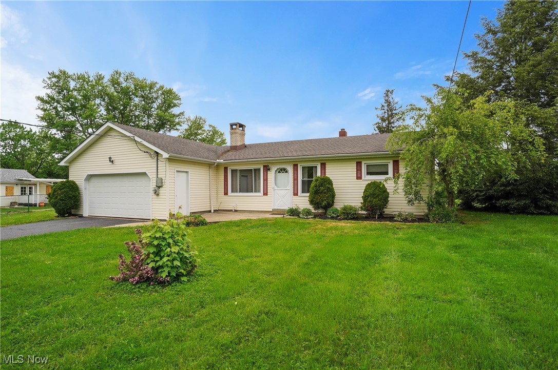 12395 Carter Road Painesville, OH 44077 - Photo 1 of 39 Ranch-style house with an attached garage, driveway, a chimney, and a front yard