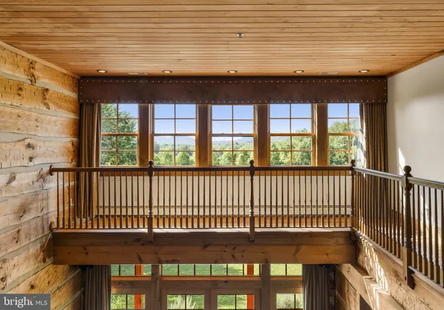 a view of a house with a large window and wooden fence