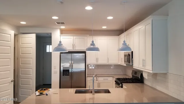 a kitchen with kitchen island a counter top space cabinets and stainless steel appliances
