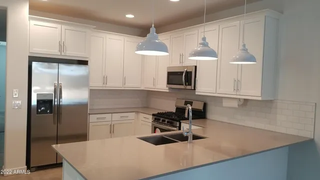 a kitchen with stainless steel appliances granite countertop a sink a stove and a refrigerator