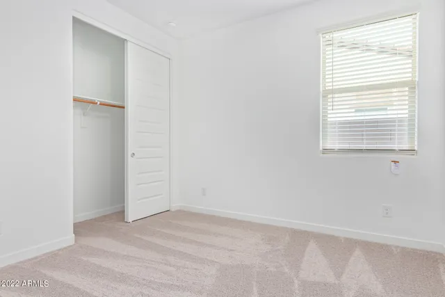 an empty room with a window and closet