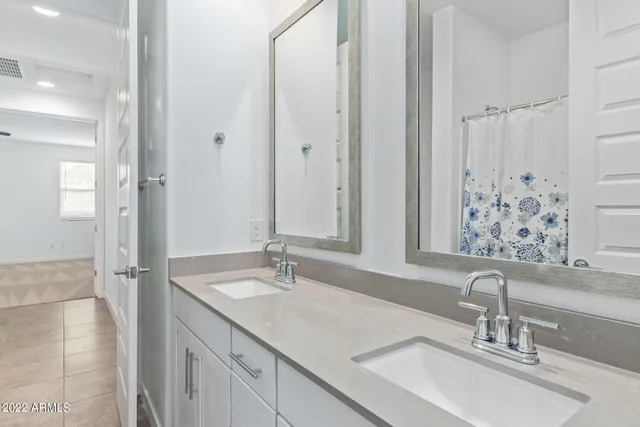 a bathroom with double vanity sinks and a mirror