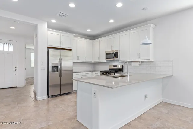 a kitchen with kitchen island a refrigerator sink and cabinets
