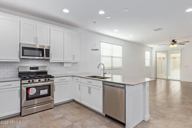 a kitchen with stainless steel appliances granite countertop a stove a sink and a microwave