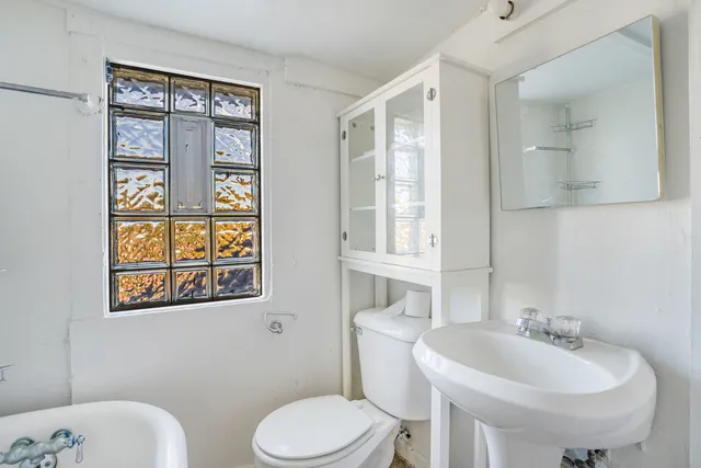 a bathroom with a toilet sink and mirror