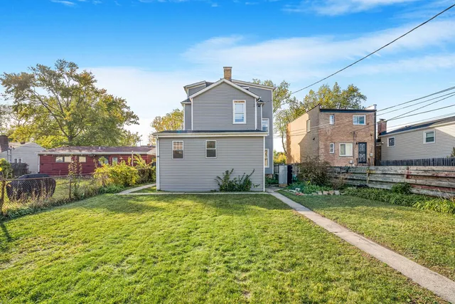 a view of a house with a big yard and large trees