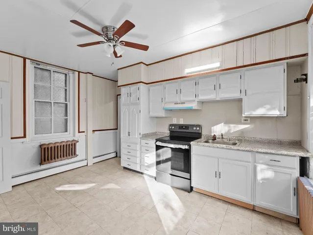 a kitchen with white cabinets and white appliances