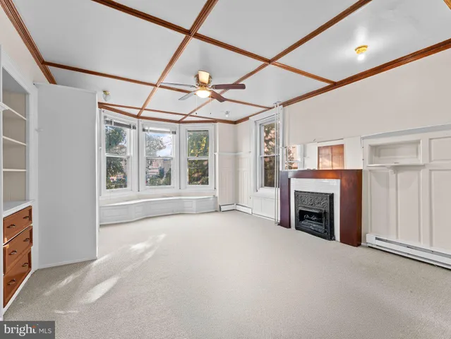 a view of an empty room with a fireplace and a window