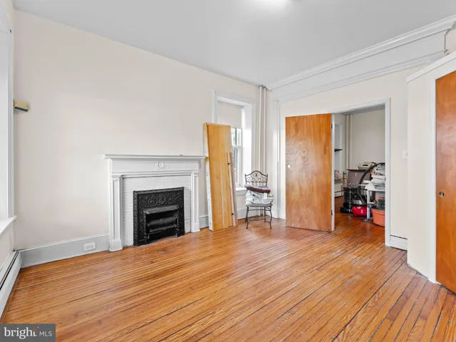 a view of empty room with wooden floor and fireplace