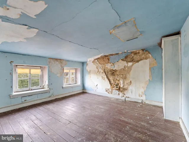 an empty room with windows and closet