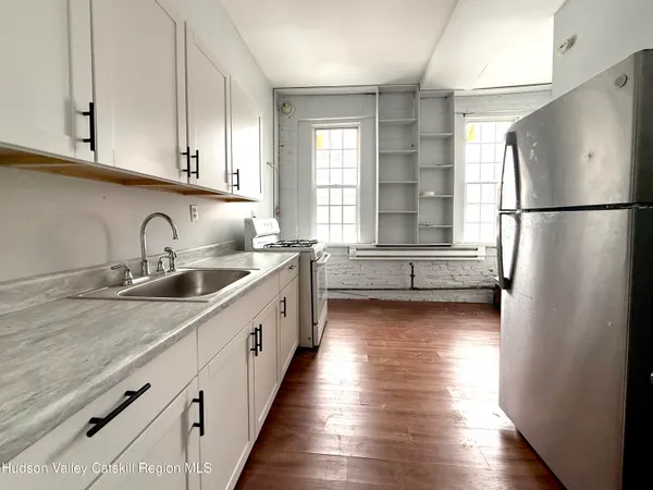 a kitchen with sink a refrigerator and window