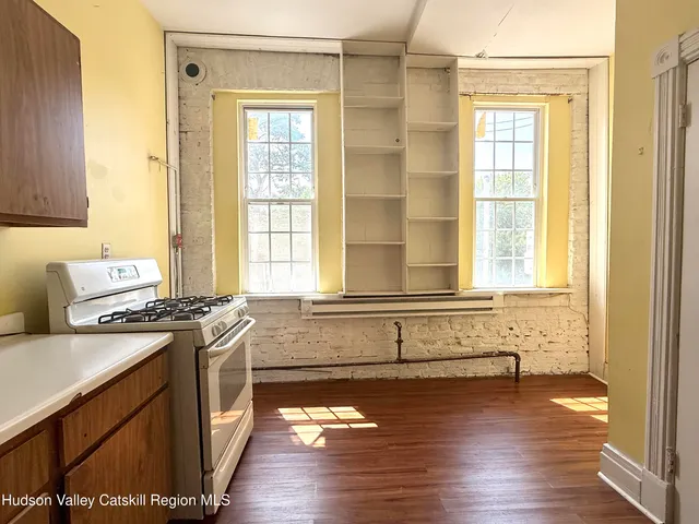 a kitchen with a wooden floor and a window