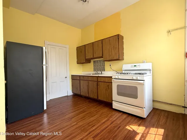 a kitchen with wooden cabinets and white appliances