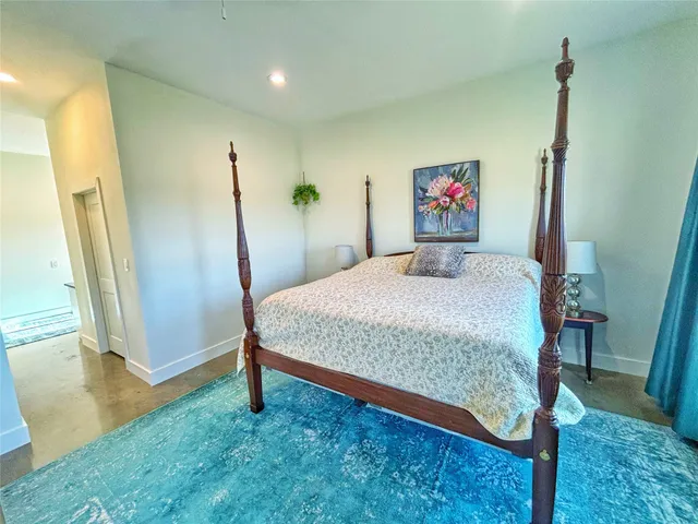 a bedroom with a bed and a painting on the wall