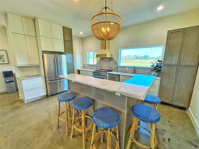 a kitchen with stainless steel appliances kitchen island granite countertop furniture and a refrigerator