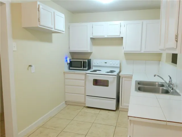 a kitchen with white cabinets and white appliances