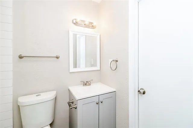 a bathroom with a toilet a sink and mirror