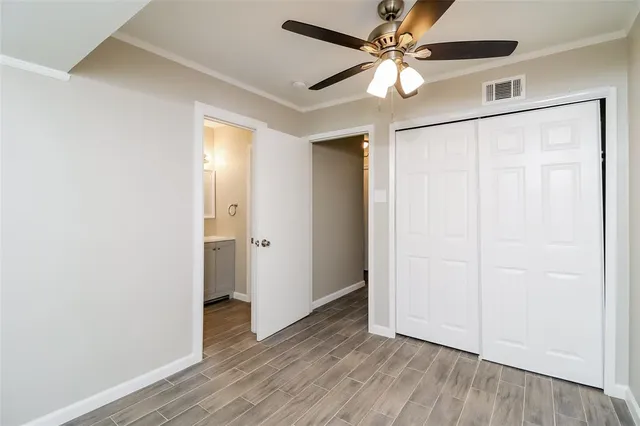an empty room with wooden floor a ceiling fan and a window