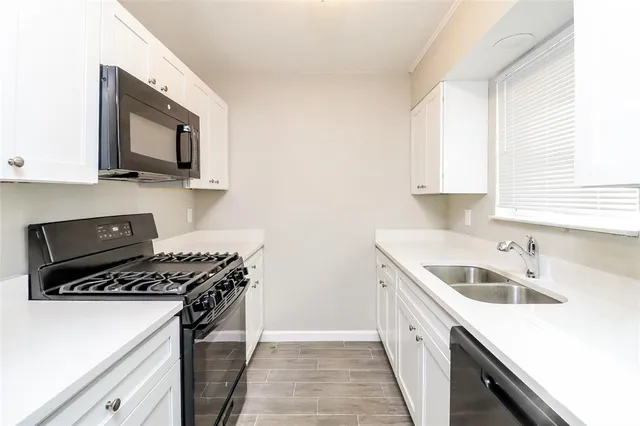 a kitchen with a sink stove top oven and cabinets