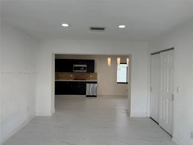 a kitchen with stainless steel appliances granite countertop a refrigerator and a stove top oven