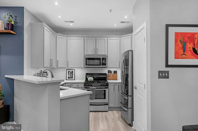 a kitchen with stainless steel appliances granite countertop a refrigerator stove and sink