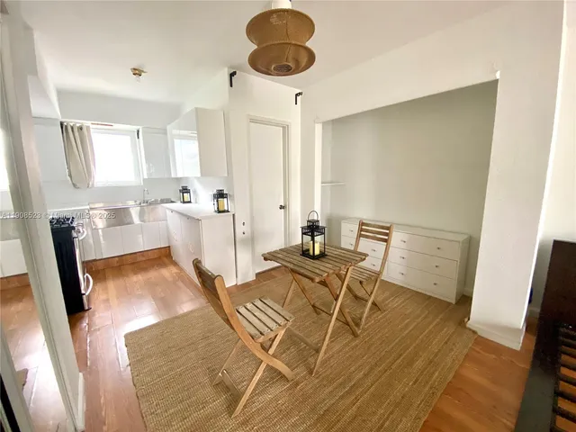 a living room with furniture a large window and stainless steel appliances