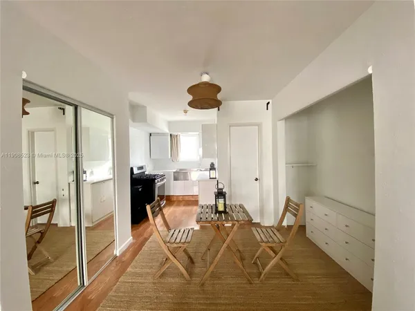 a kitchen with granite countertop cabinets a sink a window and wooden floor