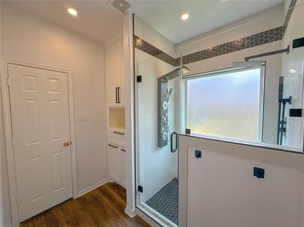 a view of a hallway with wooden floor and closet