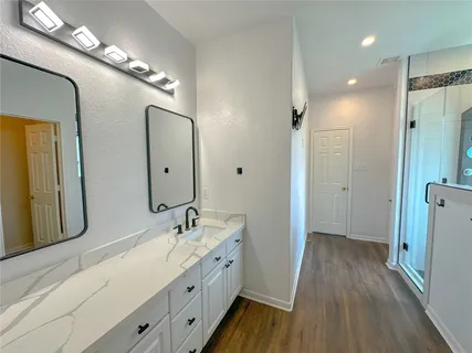 a bathroom with a glass shower door and a bathtub
