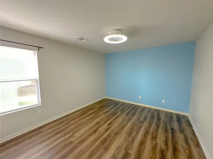 a view of a hallway with wooden floor and closet