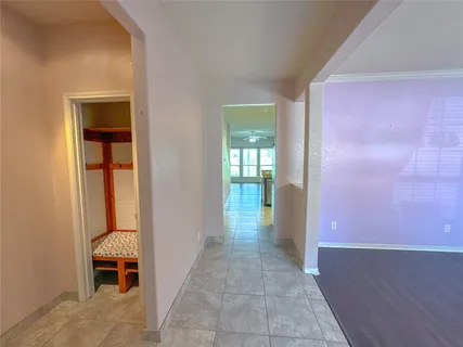 a view of a hallway with wooden floor and a living room