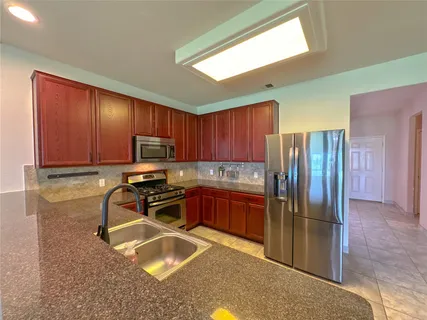 a kitchen with stainless steel appliances granite countertop a stove microwave and sink