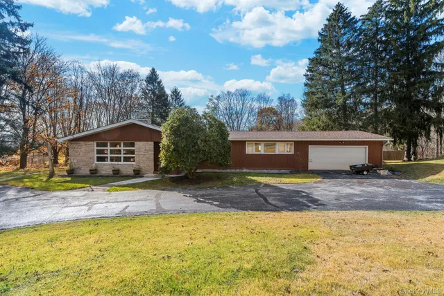 a view of a house with a yard and large tree