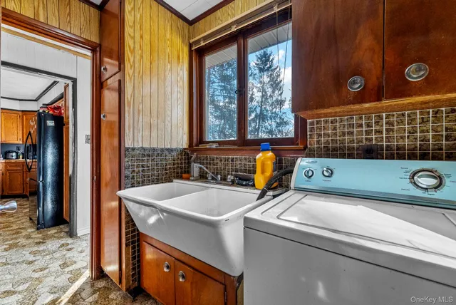 a backyard of a house with table and chairs under an umbrella