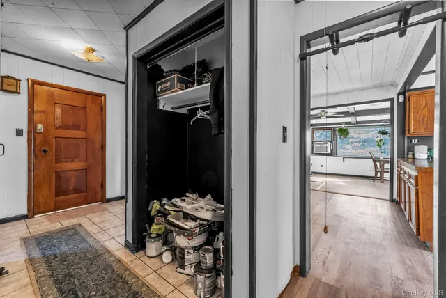 a hallway with white doors wooden floor and front door
