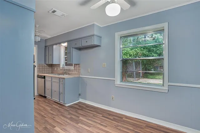 a kitchen with a sink cabinets and wooden floor