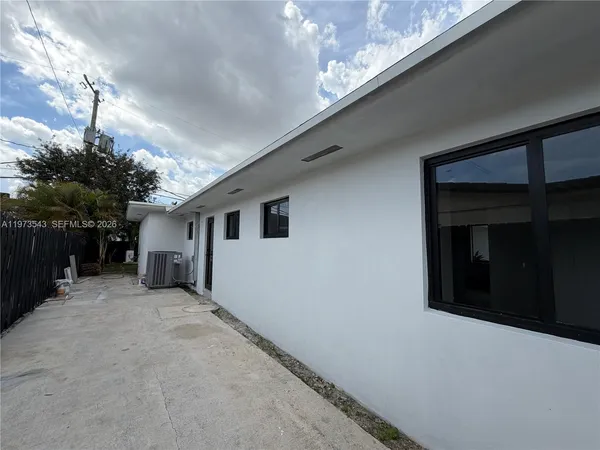 a view of a house with backyard and sitting area