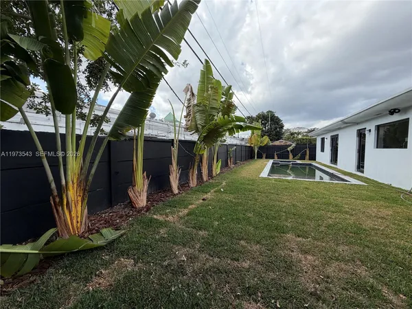 a view of a house with backyard and sitting area