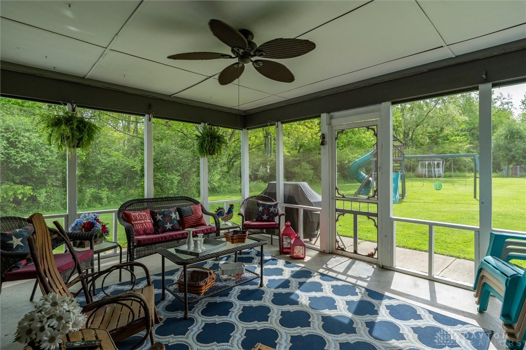 2165 Stewart Road Xenia, OH 45385 - Photo 54 of 59 This inviting screened porch offers serene views of the expansive green yard, perfect for outdoor enjoyment.
