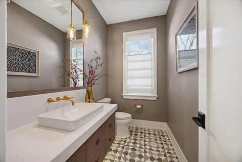 a bathroom with a sink a toilet and window